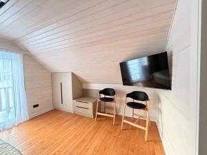 a room with two stools and a tv on a wall at Home Hill in Kozevo