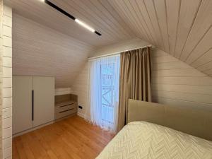 an attic bedroom with a bed and a window at Home Hill in Kozevo