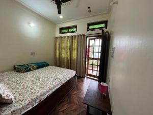 una camera con un letto e una porta con finestre di Chandarshila hike homestay a Ukhimath Altre 23 foto