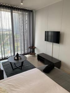 a bedroom with a bed and a table and a large window at Ellipse Luxurious Tamarind Green Studio Experience in Midrand