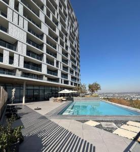 a large apartment building with a swimming pool at Ellipse Luxurious Tamarind Green Studio Experience in Midrand