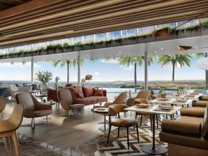 a restaurant with tables and chairs and a view of the ocean at Ellipse Luxurious Tamarind Green Studio Experience in Midrand