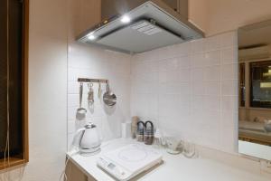 a kitchen with a sink with a coffee maker on it at Yotsuya Lantern - Private 3 stories house for family in Tokyo +30 photos