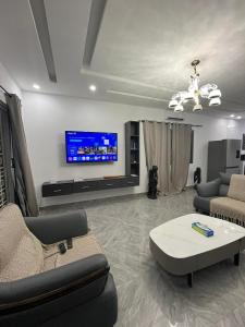 a living room with a couch and a tv at Villa John et Nini in Saly Portudal