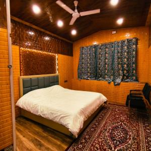 a bedroom with a bed and a ceiling fan at Id villa cottage in Tangmarg