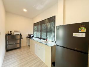 a kitchen with a refrigerator and a sink at RJJhouse Kohphangan in Ban Nua