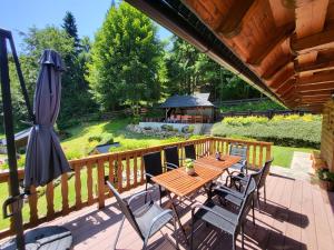 a wooden deck with a table and chairs and a gazebo at Chata pod Kykulou in Oščadnica