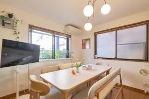 a living room with a table and chairs and a tv at Yotsuya Lantern - Private 3 stories house for family in Tokyo