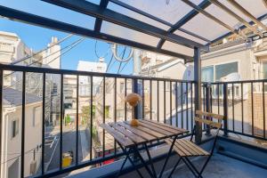 a balcony with a wooden bench and a table at Yotsuya Lantern - Private 3 stories house for family in Tokyo