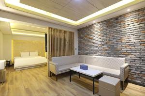 a living room with a couch and a bed at The Stay Nangman Seongseo in Daegu