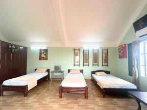 a room with three beds and a table at Ecohost Hai Trung in Háº£i Háº­u