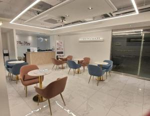 a waiting room with tables and chairs in a building at The Stay Nangman Seongseo in Daegu