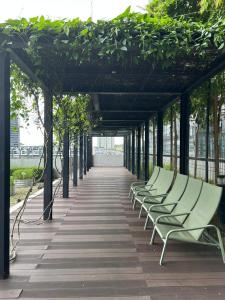 a row of green benches sitting on a walkway at Spacious 3B3R Unit in BukitJalil in Kuala Lumpur