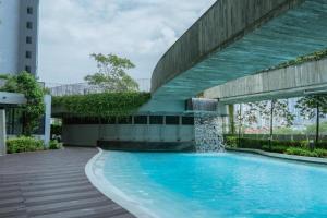 a swimming pool with a water fountain in front of a building at Spacious 3B3R Unit in BukitJalil in Kuala Lumpur