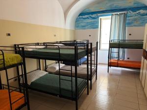 three bunk beds in a room with a mural at Seven Hostel & Rooms in Sant'Agnello