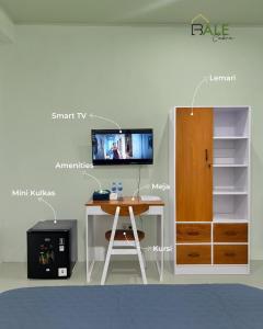 a room with a desk and a tv on a wall at Bale Cakra in Ngemplak