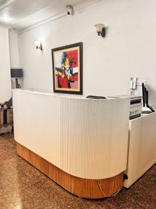 a reception desk with a painting on the wall at Reina Boutique Hotel - G9 in Islamabad