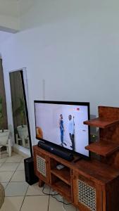 a flat screen tv sitting on a wooden entertainment center at Kwetuh in Kwale