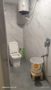 a bathroom with a toilet and a bucket in it at AERO View Residency in Bangalore