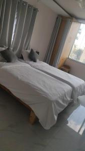 a white bed in a bedroom with a window at AERO View Residency in Bangalore