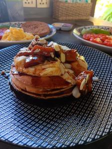 a stack of pancakes with toppings on a blue plate at Uma Mupu in Gianyar