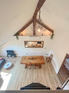 een zolderkamer met een houten tafel en stoelen bij Cocon sous les toits in Albertville +11 foto's