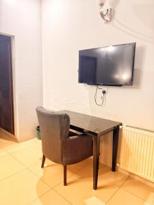 a desk with a chair and a television on a wall at Reina Boutique Hotel - G9 in Islamabad