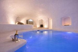 a large swimming pool with a bottle and two wine glasses at Kampanario Luxury Two-Bedroom Villa with Private Jacuzzi in Megalochori