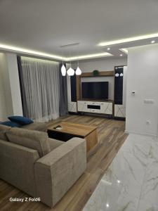 a living room with a couch and a flat screen tv at Diljanka 4 in Pernik