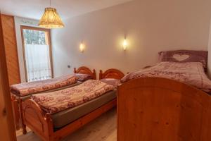a bedroom with two twin beds and a window at Appartamenti Chalet Canedi in Peio
