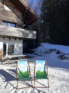 twee stoelen in de sneeuw voor een hut bij Chalet OTT - apartment in the mountains with sauna in Saint-Cergue +18 foto's