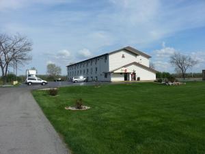 a large white building on a field of green grass at Super 8 by Wyndham Saginaw in Saginaw