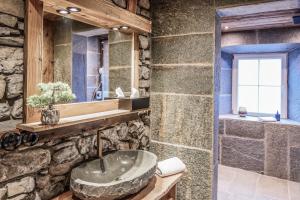 een stenen badkamer met een wastafel en een spiegel bij Chalet Bauernhaus 1864 in Elbigenalp +40 foto's