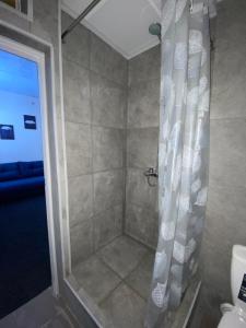 a shower with a shower curtain in a bathroom at МотельХаусSous in Svitlovodsʼk