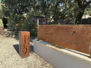 a sign with writing on it next to a wall at Les Tournillayres in Bédoin +8 photos