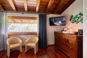 a room with two chairs and a dresser and a window at Dream's hill in San Pietro di Feletto