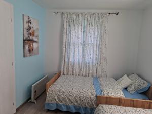 a small bedroom with a bed and a window at Šumarac in Karadak
