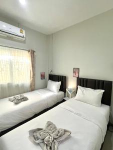 twee bedden in een kamer met witte lakens bij Yada House twin bed in Nai Yang Beach