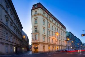 un edificio blanco alto con un reloj encima en Exe City Park Hotel en Praga