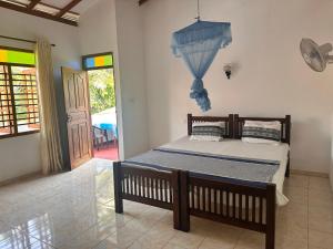 a bedroom with a bed with an umbrella on the wall at Chamila's place in Nikawatawana