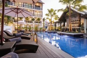 a hotel with a swimming pool and a resort at Narinthra Heritage in Chiang Mai