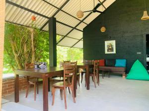 a dining room with tables and chairs and a couch at Thihawa Yala in Tissamaharama