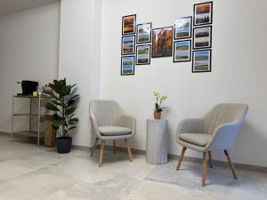 twee stoelen in een kamer met foto's aan de muur bij Casa di Stella in Montepulciano