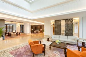 a lobby of a hotel with a couch and chairs at Grand Hotel De Djokja in Yogyakarta +71 photos