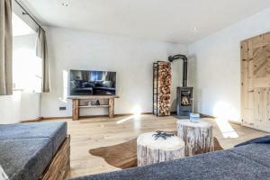 een woonkamer met een bank en een houtkachel bij Chalet Bauernhaus 1864 in Elbigenalp