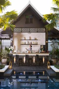 a bar in front of a house with a swimming pool at Narinthra Heritage in Chiang Mai