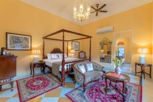 a bedroom with a canopy bed and a chair at Abheygarh in Khetri