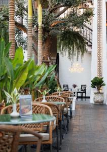 a patio with tables and chairs and palm trees at Narinthra Heritage in Chiang Mai