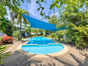 an image of a swimming pool in a yard with trees at Tropical Mango House Stay in Airlie Beach