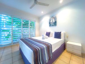 a bedroom with a large bed and a window at Tropical Mango House Stay in Airlie Beach
